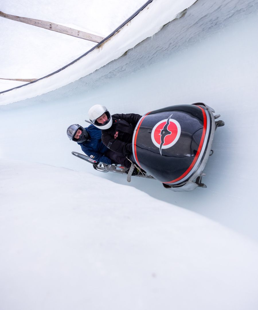 Zwei Gäste im Zweierbob in der Eisrinne